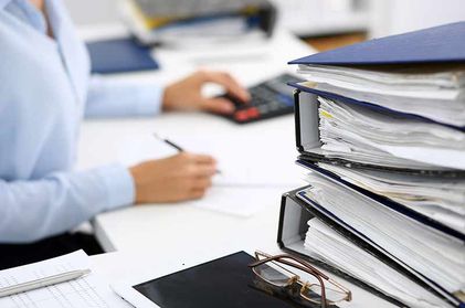 Buchhalter mit Aktenordnern bei der Arbeit in Schwaz in Tirol